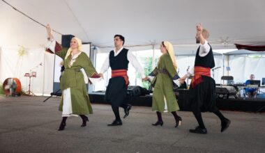 four people dancing in traditional greek clothing