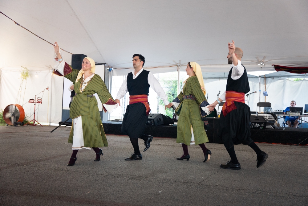 four people dancing in traditional greek clothing
