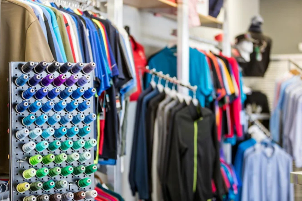 colorful thread options with colorful shirts behind them