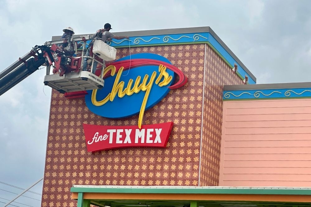 Workers install signage at Bastrop’s first Chuy’s ahead of the restaurant’s planned May 18 opening at Sendero.
