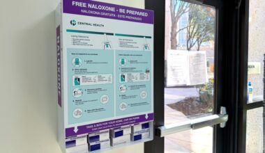 Naloxone distribution unit on a wall near a door