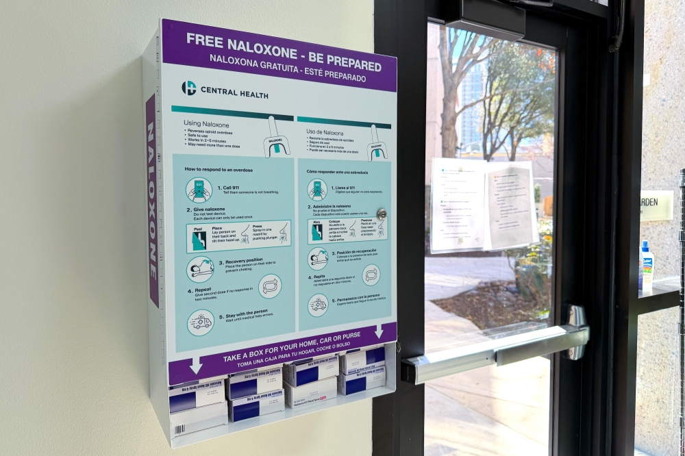 Naloxone distribution unit on a wall near a door
