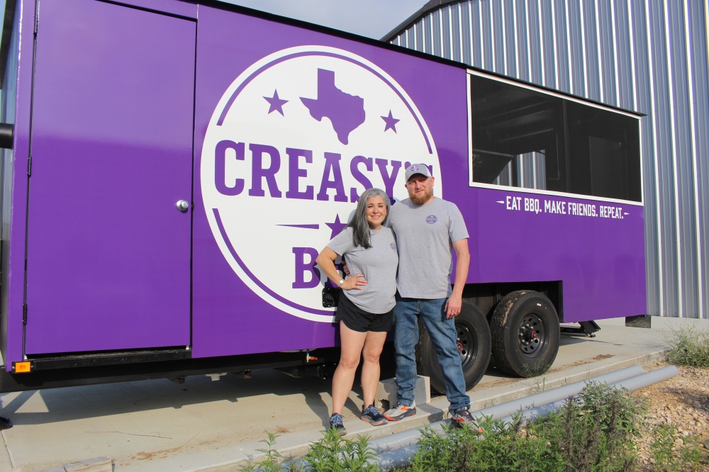 Erika and Ryan Chody stand with their custom-built food truck. They will launch the truck's operations in May. (Brooke Sjoberg/Community Impact)