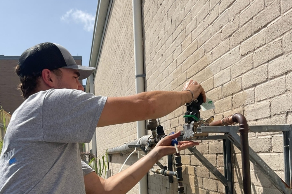 Ott Plumbing Service Manager David Fetters works on the exterior plumbing of a home in New Braunfels. (Courtesy Ott Plumbing)