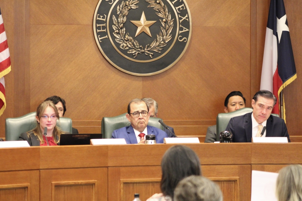 From left, committee clerk Haylee Plumley, Sen. Pete Flores, R-Pleasanton, and Rep. Morgan Meyer, R-University Park, hold back tears while listening to testimony from CiCi Steward, whose daughter, Cile, remains unaccounted for after the July 4 flood at Camp Mystic. (Hannah Norton/Community Impact)