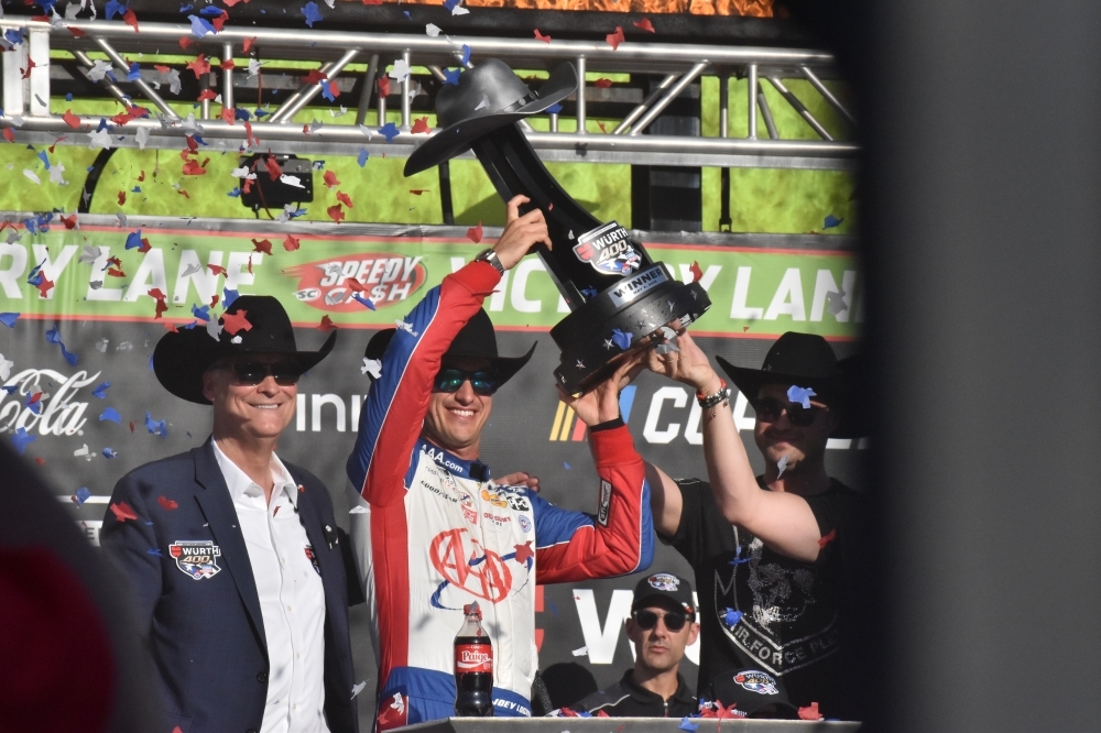 NASCAR Cup Series driver Joey Logano, center, holds up the trophy for winning the WÜRTH 400 last May in Fort Worth. (Cody Thorn/Community Impact)