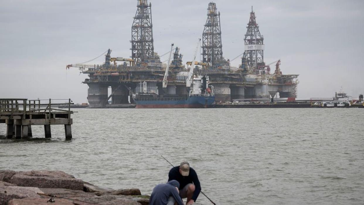 <div>FILE - People fish in front of defunct oil drilling rigs in the Corpus Christi Ship Channel at Aransas Pass on March 11, 2019, in Port Aransas, Texas. (Photo credit: LOREN ELLIOTT/AFP via Getty Images)</div>