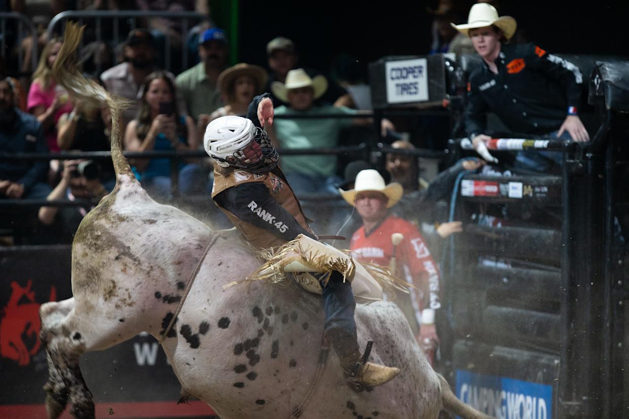 People watch as rider Ethan Winckler attempts to stay in control on a bull named Spotted Demon during the Professional Bull Riders Pendleton Whisky Velocity Tour Finals in Corpus Christi on May 3, 2025.