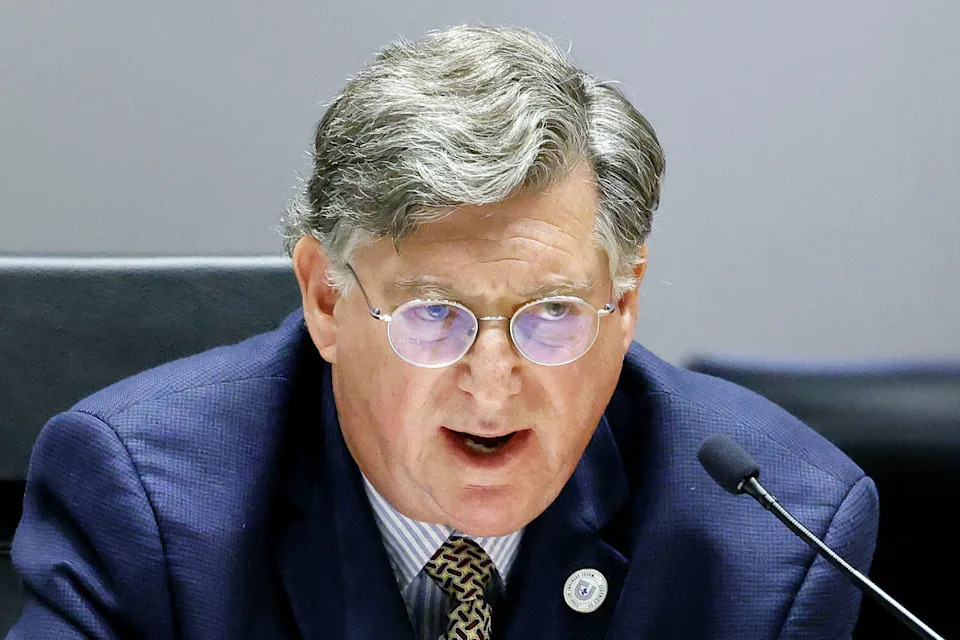 Economic Development Committee member William Roth asks questions of Planning and Development Deputy Director Andreea Udrea during a hearing about whether or not to spend consulting money to buy out a pair of shingle manufacturers. The committee heard a consideration of a resolution directing the city manager to utilize contingency reserve funds to procure a consultant for GAF and Tamko shingle manufacturers to shut down during a meeting at Dallas City Hall, April 6, 2026. (Tom Fox/The Dallas Morning News)
