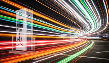 An abstract, colorful image of an electric vehicle charging station, with the charger and surrounding environment blurred into dynamic, sweeping streaks of motion, conveying the speed and energy of modern transportation.