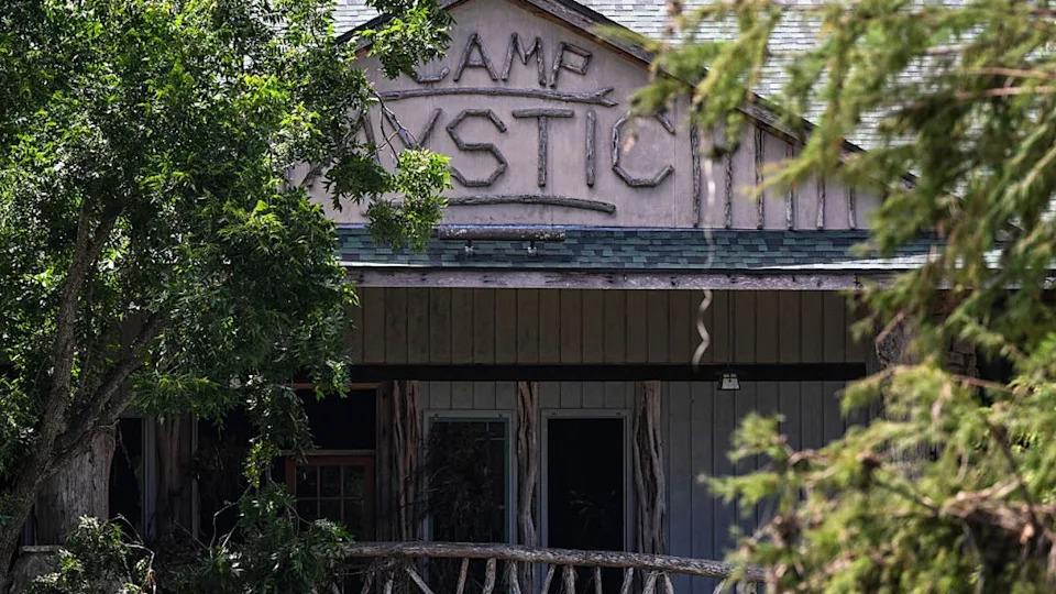<div>View of Camp Mystic's central gathering space, the Recreation Hall, surrounded by damaged structures and fallen trees along the Guadalupe River in Hunt, Texas, on July 8, 2025, after severe flash flooding over the July 4 holiday weekend. (Photo by RONALDO SCHEMIDT / AFP) (Photo by RONALDO SCHEMIDT/AFP via Getty Images)</div>