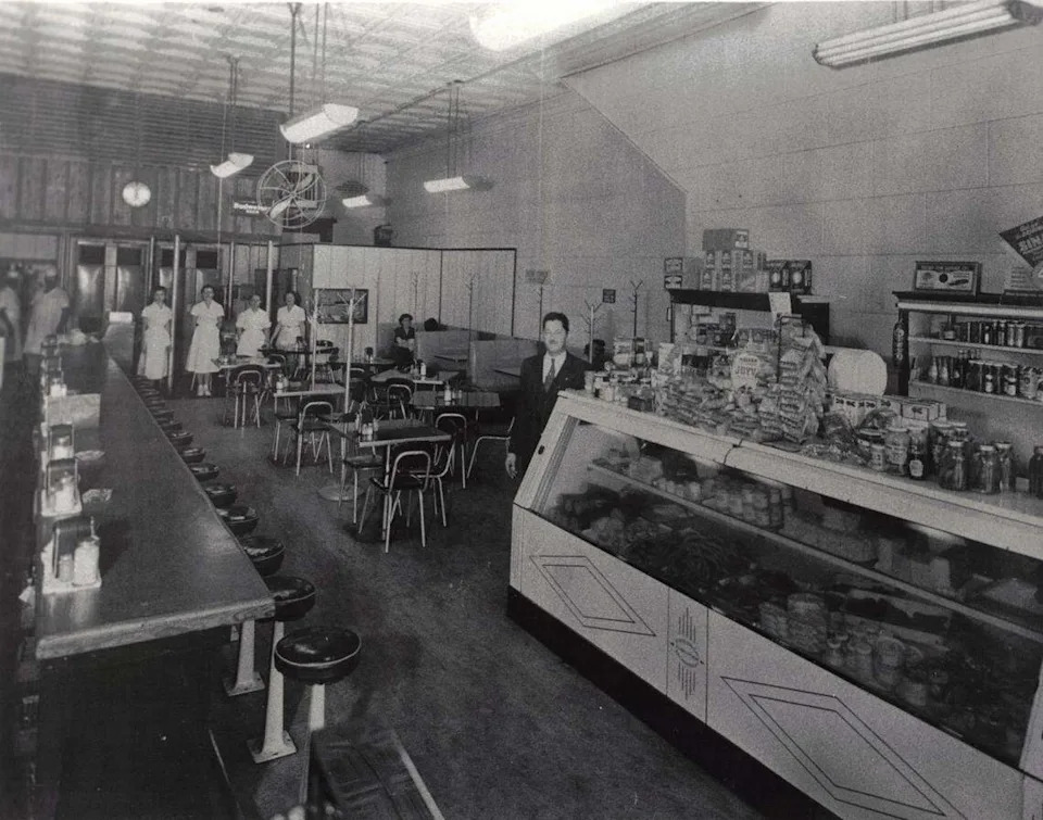 The interior of Carshon’s deli at 1010 Houston St. in 1951 shows owner Abe Applebaum near the deli counter, which is stocked on top with his wife’s homemade dill pickles and with halva, a Middle Eastern sweet. In the background, wearing white uniforms,  are two butchers and four waitresses.  