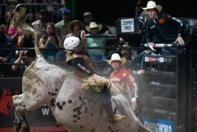 People watch as rider Ethan Winckler attempts to stay in control on a bull named Spotted Demon during the Professional Bull Riders Pendleton Whisky Velocity Tour Finals in Corpus Christi on May 3, 2025.