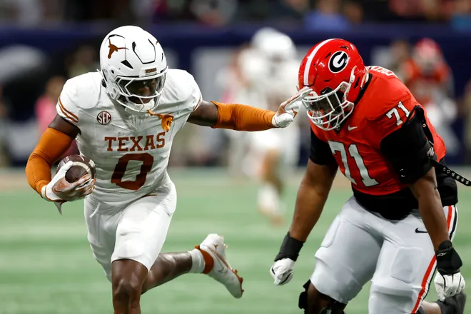Anthony Hill Jr. of the Texas Longhorns runs the ball against Earnest Greene III of the Georgia Bulldogs