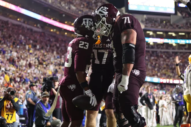Oct 25, 2025; Baton Rouge, Louisiana, USA; Texas A&M Aggies running back Jamarion Morrow (23) celebrates with offensive lineman Chase Bisontis (71) and tight end Theo Melin Ohrstrom (17) after a touchdown during the second half against the Louisiana State Tigers at Tiger Stadium. Mandatory Credit: Stephen Lew-Imagn Images