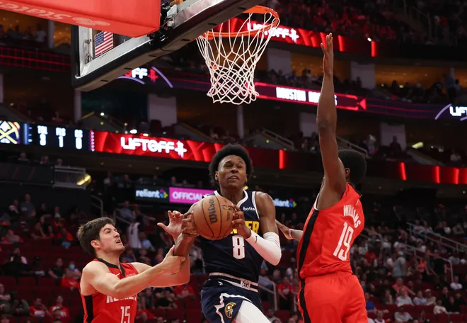 Apr 13, 2025; Houston, Texas, USA; Denver Nuggets forward Peyton Watson (8) splits the defense of Houston Rockets guard Reed Sheppard (15) and Houston Rockets guard (19) in the second half at Toyota Center. Mandatory Credit: Thomas Shea-Imagn Images