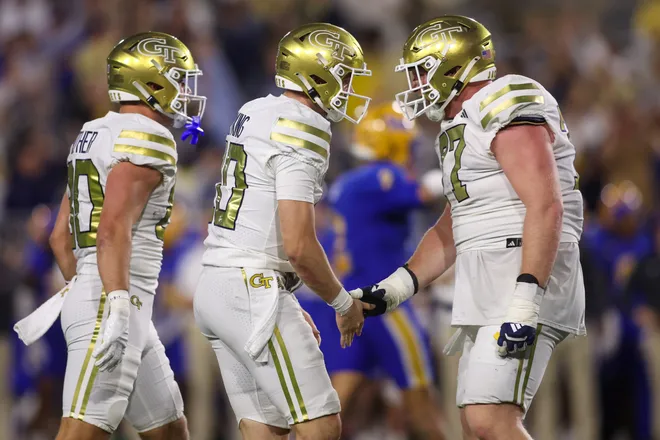 Nov 22, 2025; Atlanta, Georgia, USA; Georgia Tech Yellow Jackets quarterback Haynes King (10) celebrates with offensive lineman Keylan Rutledge (77) after a touchdown pass against the Pittsburgh Panthers in the second quarter at Bobby Dodd Stadium at Hyundai Field. Mandatory Credit: Brett Davis-Imagn Images