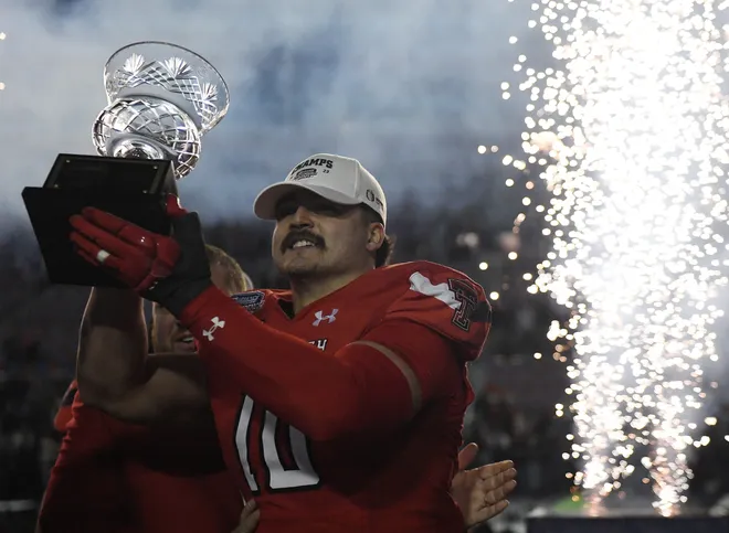 Texas Tech's linebacker Jacob Rodriguez (10) raises the defensive player of the Independence Bowl game trophy, Saturday, Dec. 16, 2023, at Independence Stadium in Shreveport, La.