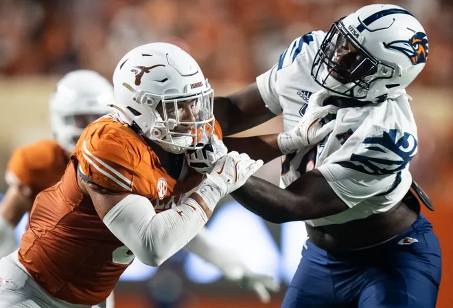 Sep 14, 2024; Austin, Texas, USA; Texas Longhorns linebacker Trey Moore (8) grapples with a member of the UTSA offense in the third quarter against the UTSA Roadrunners at Darrell K Royal–Texas Memorial Stadium. Mandatory Credit: Sara Diggins/USA TODAY Network via Imagn Images
