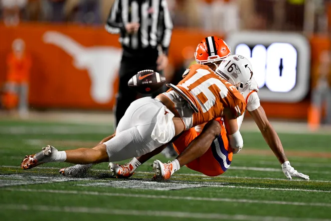 Dec 21, 2024; Austin, Texas, USA; Texas Longhorns defensive back Michael Taaffe (16) tackles Clemson Tigers wide receiver T.J. Moore (1) for a stop on a fourth down attempt during the second half of the CFP National Playoff first round game at Darrell K Royal-Texas Memorial Stadium. Mandatory Credit: Jerome Miron-Imagn Images