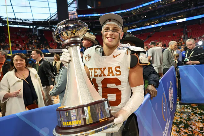 Jan 1, 2025; Atlanta, GA, USA; Texas Longhorns defensive back Michael Taaffe (16) poses with the trophy after a victory over the Arizona State Sun Devils in the Peach Bowl at Mercedes-Benz Stadium. Mandatory Credit: Brett Davis-Imagn Images