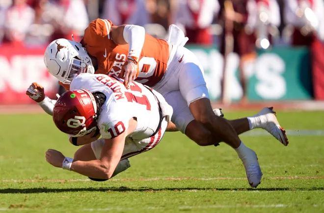 Texas Longhorns defensive back Michael Taaffe (16) tackles Oklahoma Sooners quarterback John Mateer (10) in the first half of the Red River Rivalry college football game between the University of Oklahoma Sooners and the Texas Longhorn at the Cotton Bowl Stadium in Dallas, Texas, Saturday, Oct. 11, 2025.