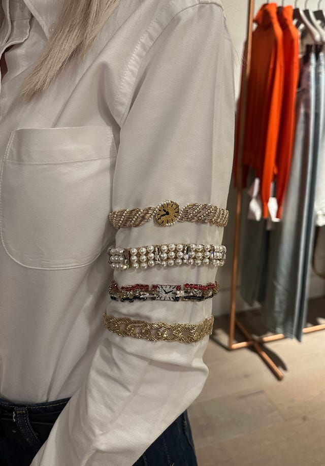 Arm adorned with multiple decorative bracelets.