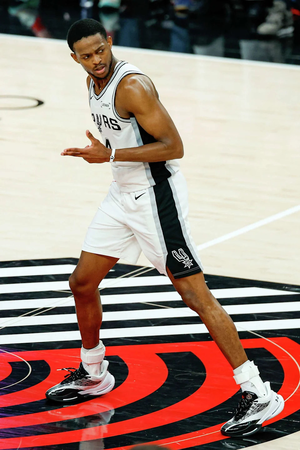 San Antonio Spurs guard De'aaron Fox (4) signals after making a shot against the Portland Trail Blazers during the fourth quarter of Game 4 of a first-round NBA playoff series at Moda Center on Sunday, April 26, 2026. The Spurs won 114-93, leading the series 3-1. (Sam Owens/San Antonio Express-News)