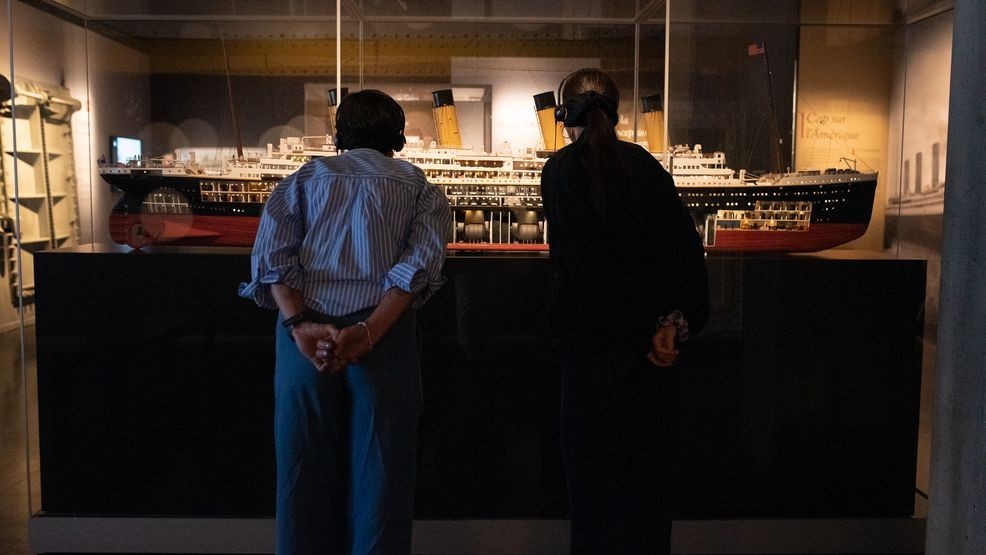 Attendees gather around display cases, getting a closer look at the small, personal items that survived the tragedy.  (Credit: Jennifer Marcuson – ICÔNE)