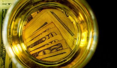 Twenty dollar bills at beneath the bottom of a beer glass.