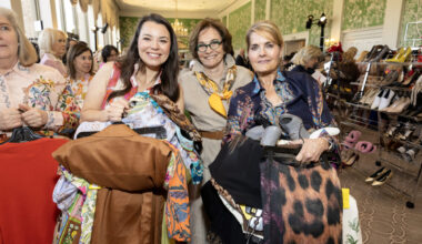 Fashionable ladies scoop up armloads of gently used/brand new clothing at the Salvation Army Auxiliary Reflections on Style luncheon.