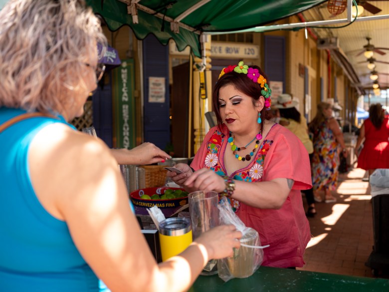 Cynthia Paniagua, an employee at the La Margarita vendor booth, works her shift on the day after a shooting left a man in critical condition in Historic Market Square during Fiesta De Los Reyes.