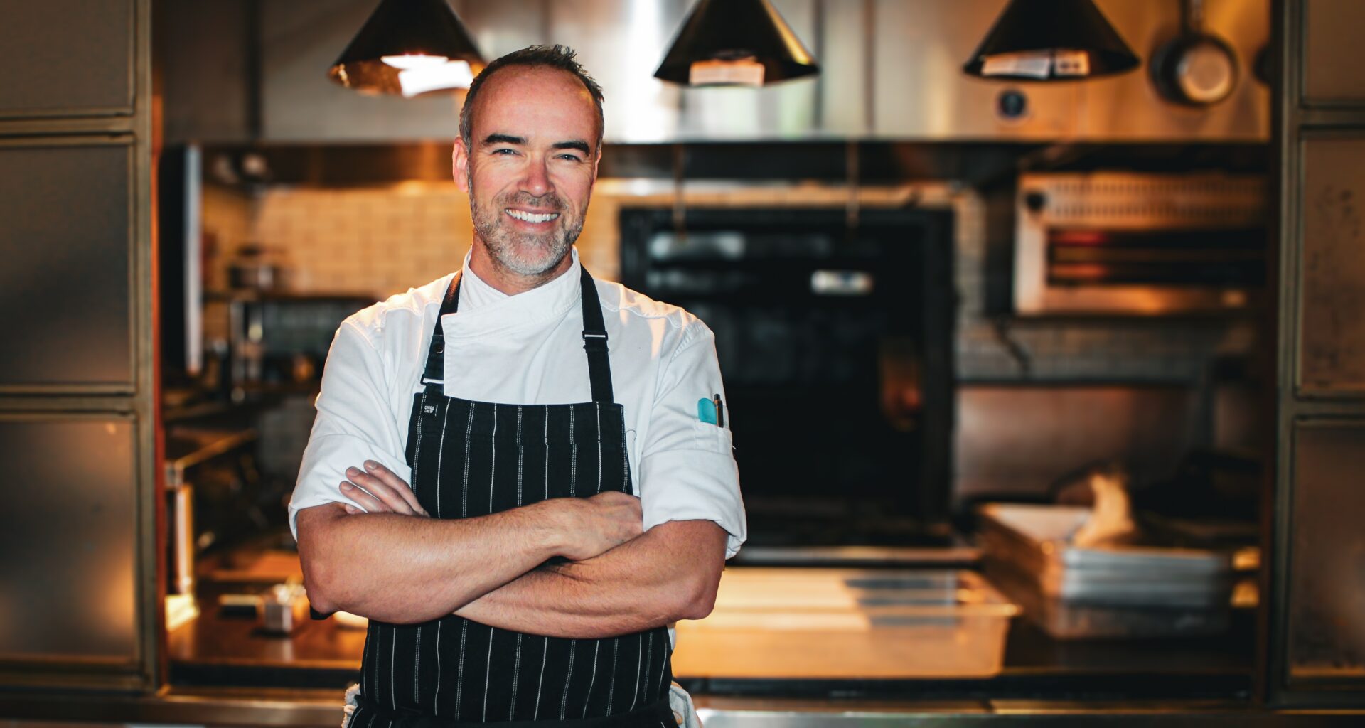 Chef Toby Archibald stands in front of his kitchen at Quarter Acre.