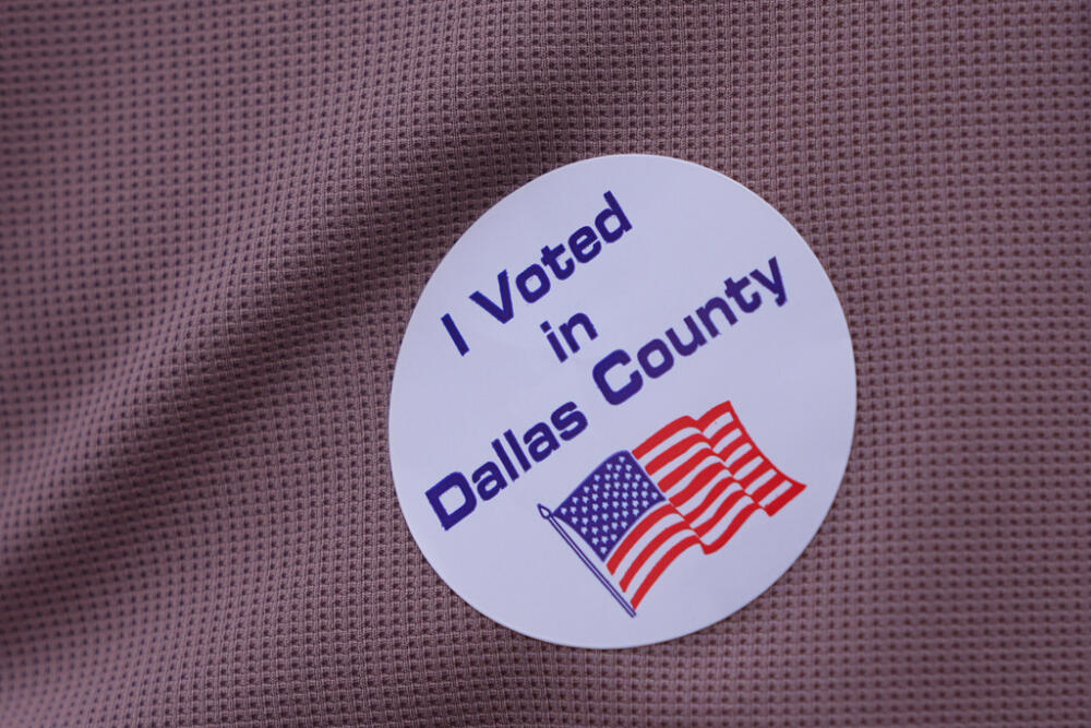 A primary voter wears a sticker after casting a ballot at a voting center in Dallas, Tuesday, March 3, 2026. (AP Photo/LM Otero)