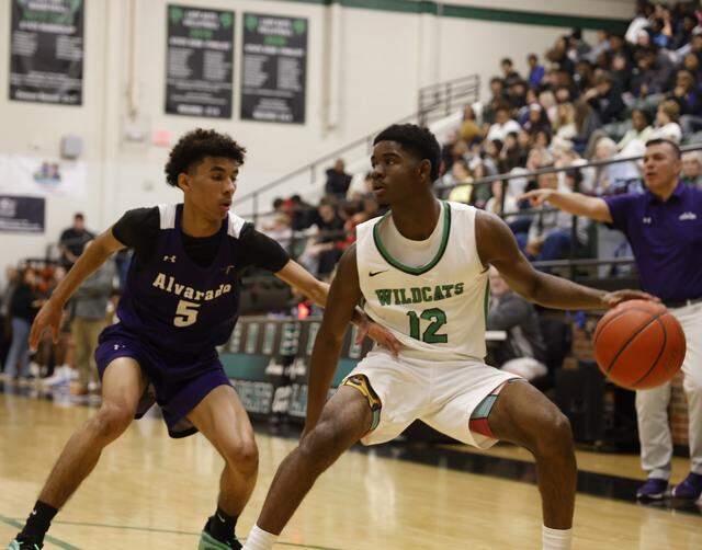 Kennedale guard Jacoby Lovings (right) looks for an opening against Alvarado guard Brendyn Webb during the first half Jan. 13 at Kennedale.