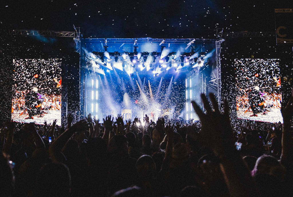 Image shows a stage at night from the POV of the crowd.