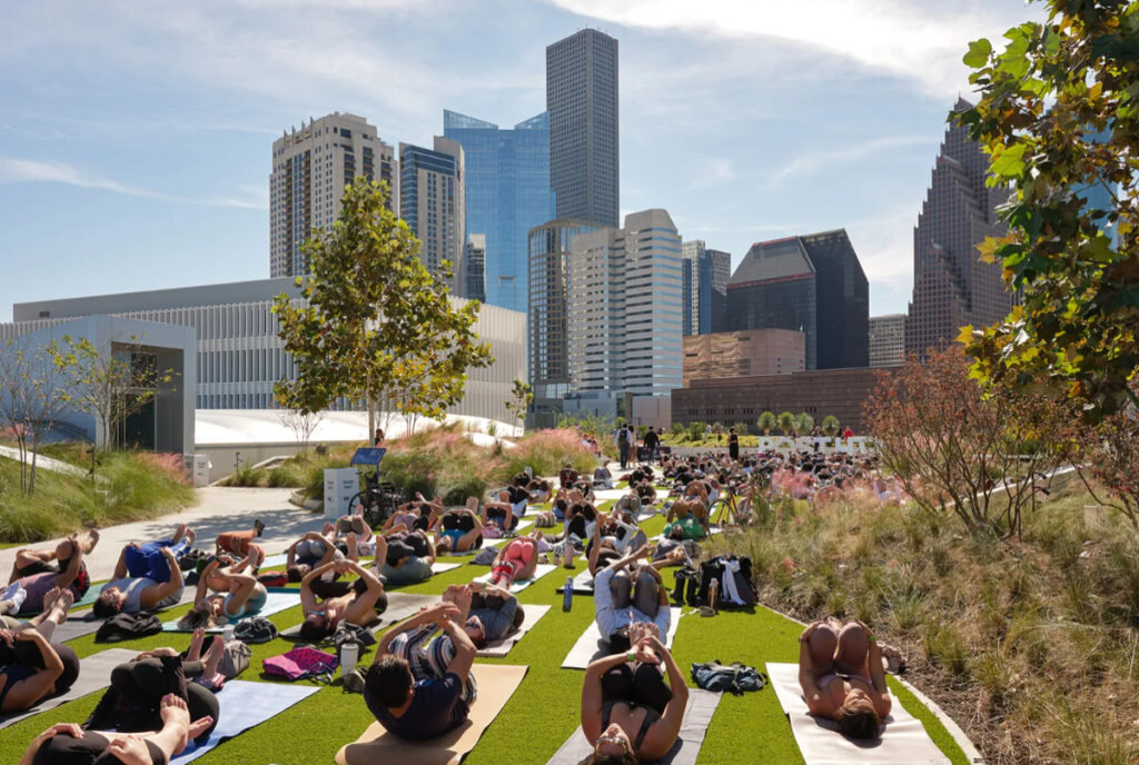 Image shows a group participating in rooftop yoga at POST Houston.