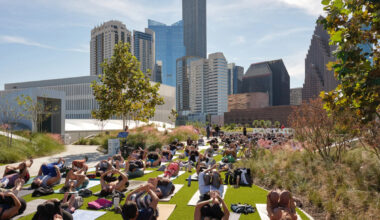 Image shows a group participating in rooftop yoga at POST Houston.