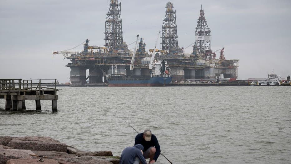 FILE - People fish in front of defunct oil drilling rigs in the Corpus Christi Ship Channel at Aransas Pass on March 11, 2019, in Port Aransas, Texas. (Photo credit: LOREN ELLIOTT/AFP via Getty Images)