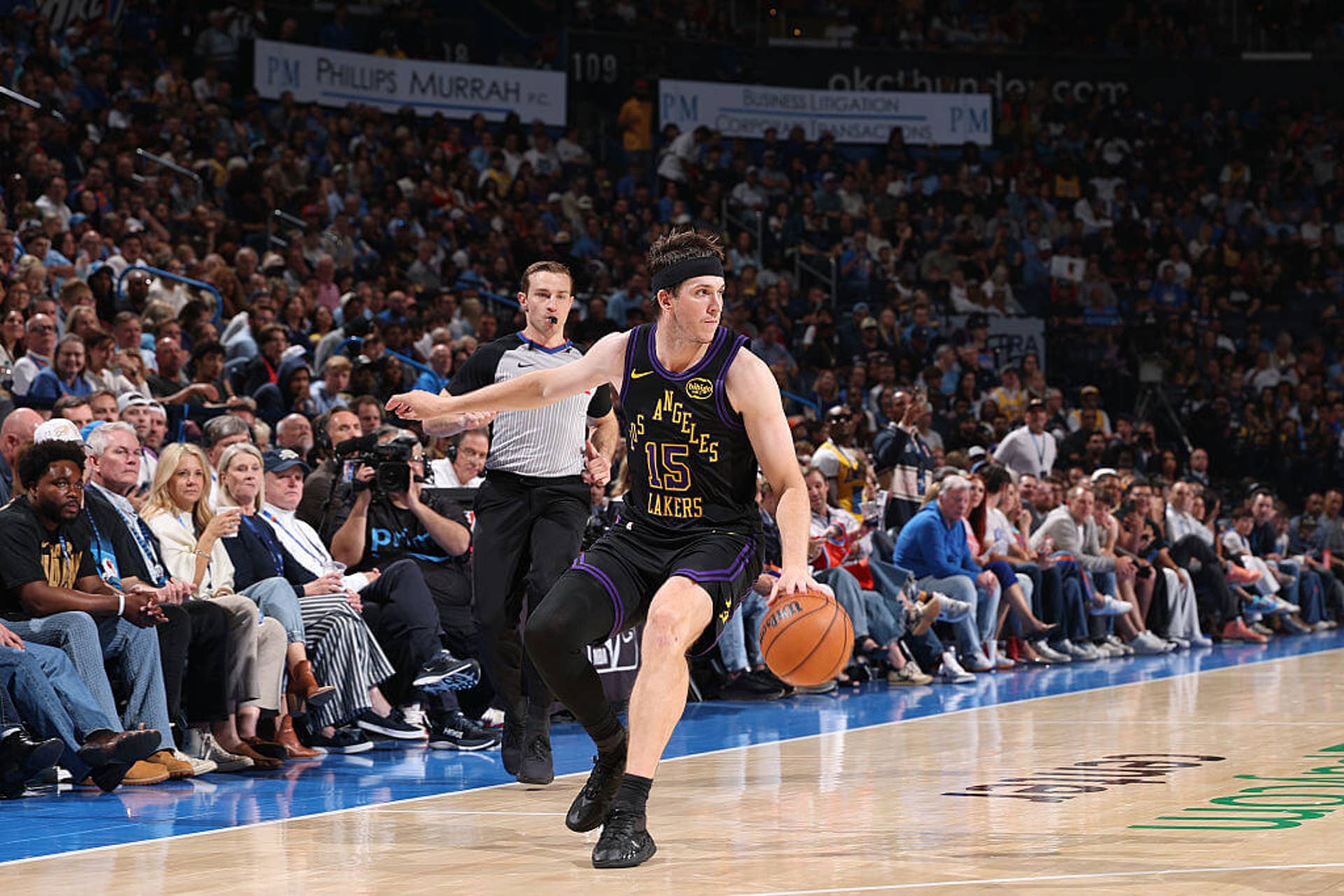 Austin Reaves looks on while dribbling during a Lakers game.