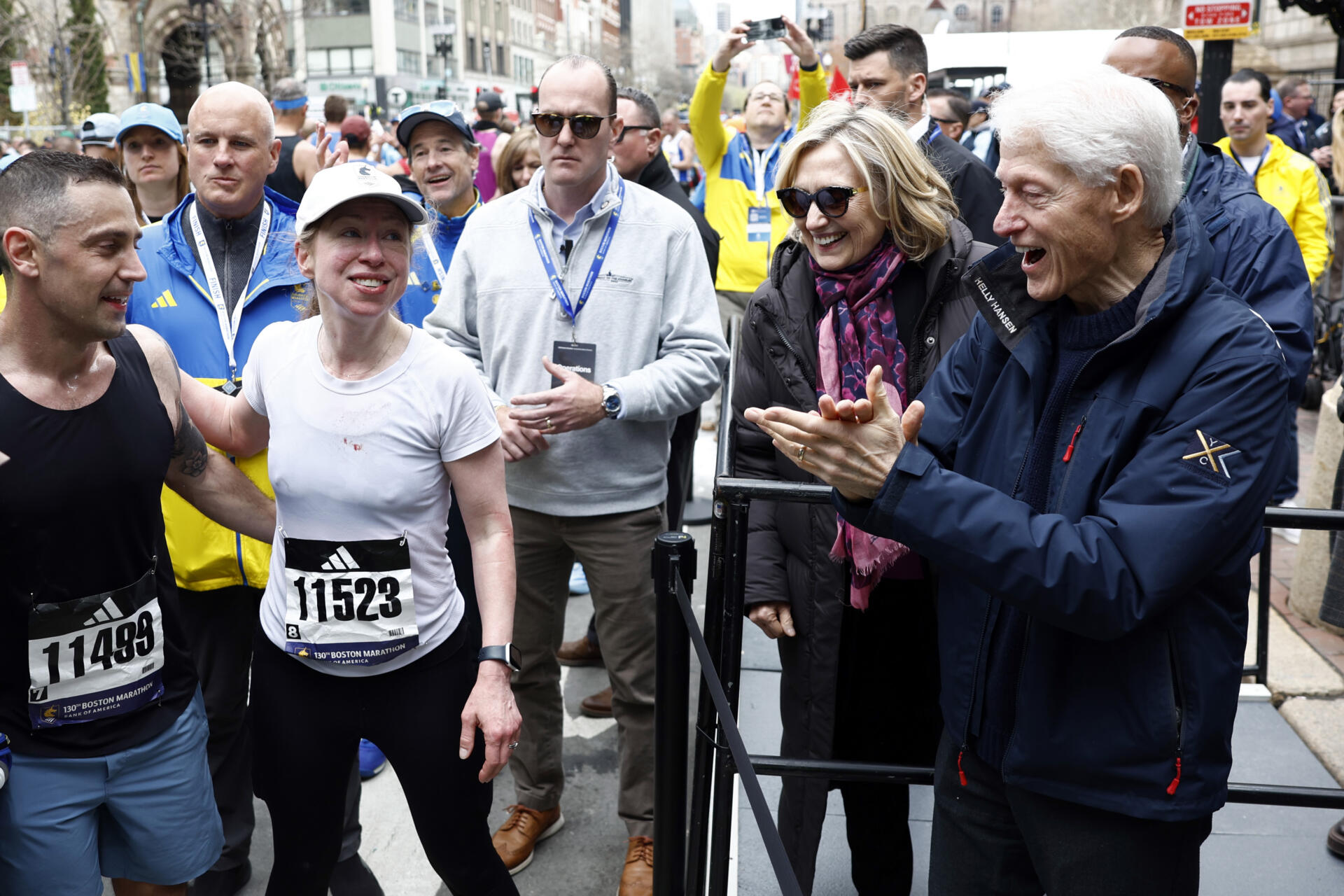 Bill and Hillary Clinton applaud their daughter, Chelsea Clinton, after she finished the 130th Boston Marathon on April 20, 2026. (Danielle Parhizkaran/The Boston Globe via Getty Images)