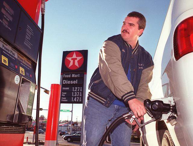 Dec. 23, 1999: Lendon Bridges gasses up his company van at a gas station in Grapevine. Bridges works for a freight delivery service and doesn't really pay attention to the gas price when fueling his work van because he uses a company credit card.
