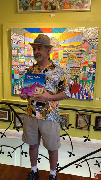 Artist Hal Marcus holds a children's book titled "Buenas Noches, El Paso."