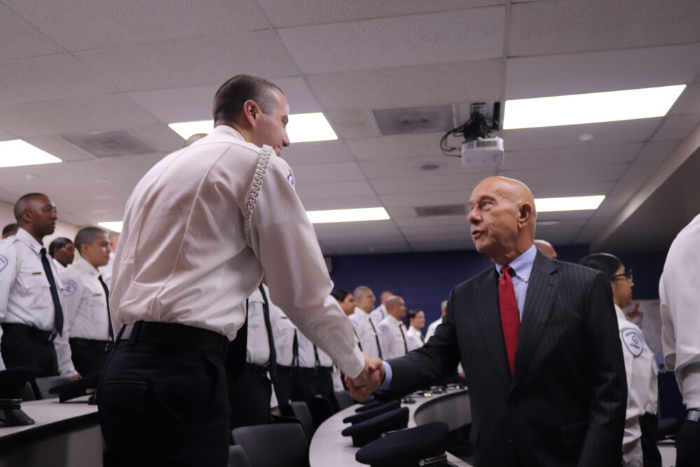 A police cadet shakes hands with John Whitmire