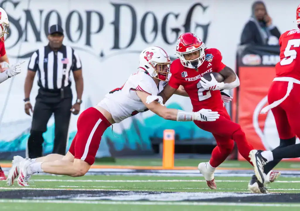 Could These 2 Sleepers Fix Dallas' Linebacker Depth? 2026 NFL Draft prospect Jackson Kuwatch of Miami (Ohio) wraps up Fresno State running back Malik Sherrod during a game, diving low for a tackle as Sherrod tries to cut upfield.