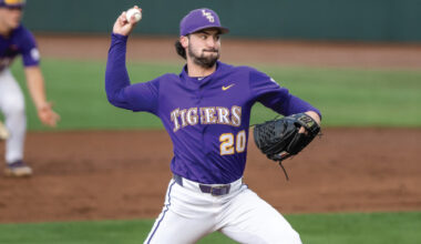 Right-handed baseball pitcher in a purple Tigers uniform (number 20) mid-pitch on the mound, glove on his left hand.