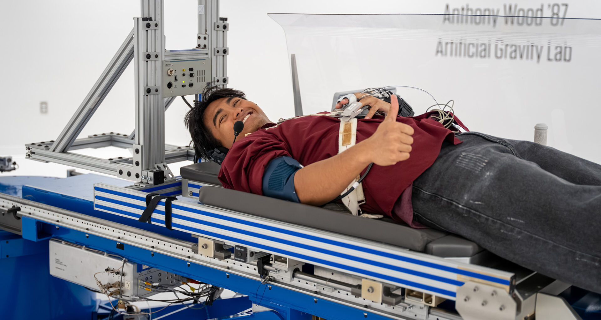 A photo of a student laying on a platform for a centrifuge.