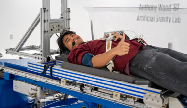 A photo of a student laying on a platform for a centrifuge.