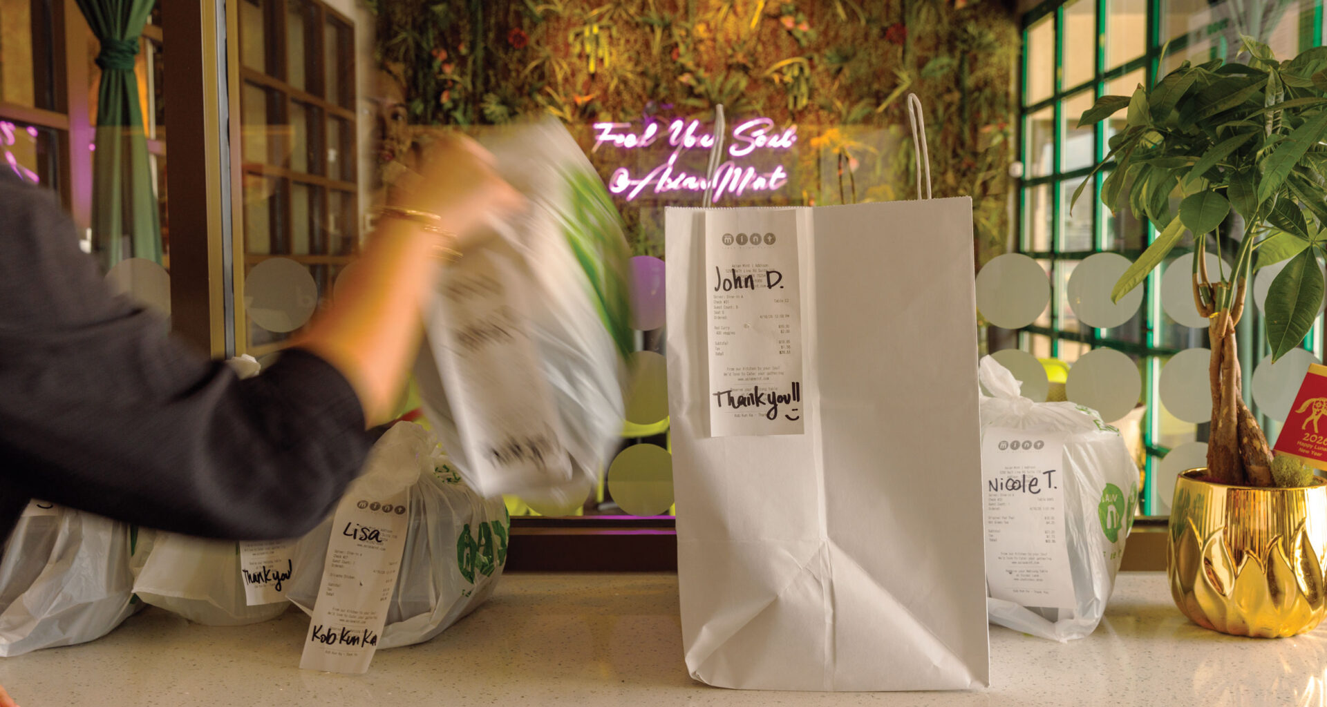 take out bags sitting on a counter, one is being removed.