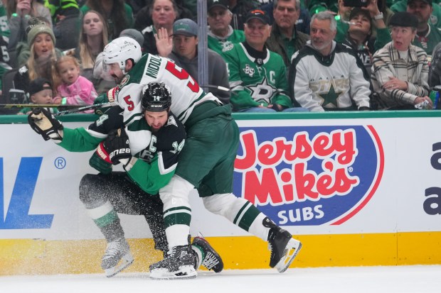 Dallas Stars left wing Jamie Benn (14) and Minnesota Wild defenseman Jake Middleton (5) get tangled up on a play during the first period in Game 1 of a first-round NHL Stanley Cup playoffs hockey series, Saturday, April 18, 2026, in Dallas, Texas. (Julio Cortez)